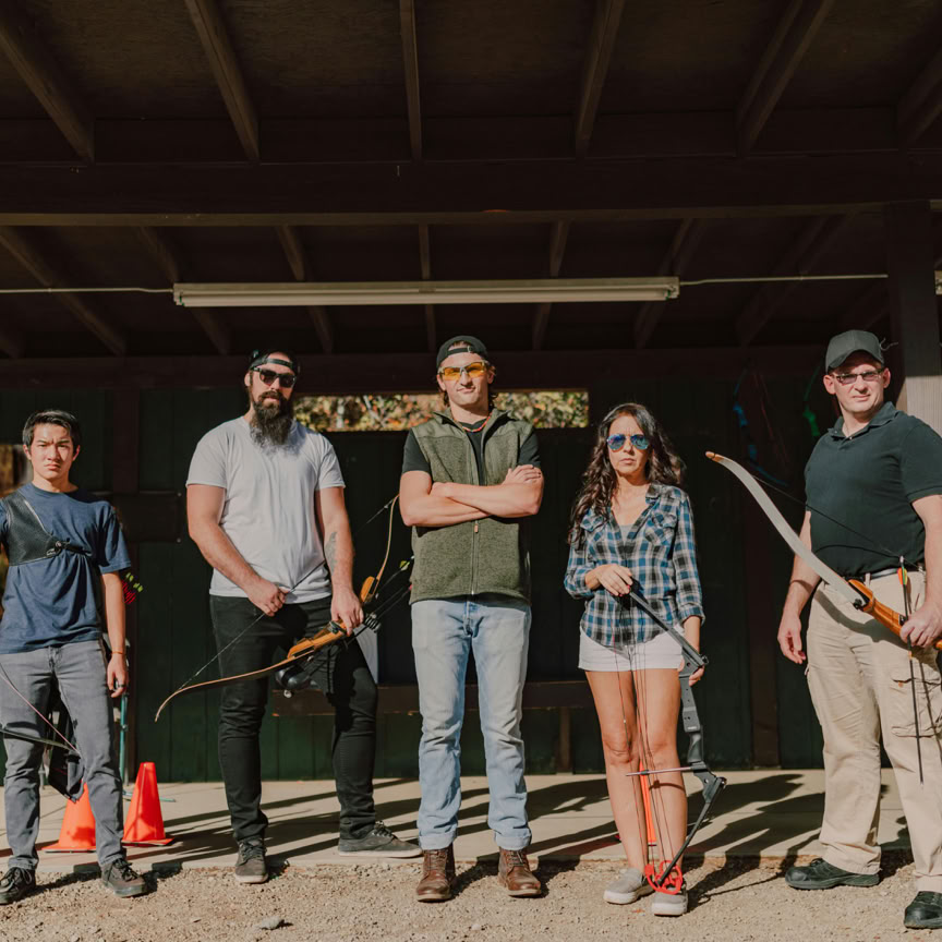Eine Gruppe Von Menschen, Die Bögen Auf Der Bogenschießanlage Halten